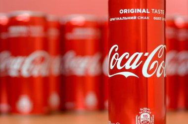 Coca-Cola logosu alüminyum kutulara baskılı ve alışveriş merkezi masasına yerleştirilir