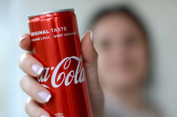 Mujer feliz sosteniendo lata de aluminio Coca-Cola sin alcohol en el interior del garaje — Foto de Stock