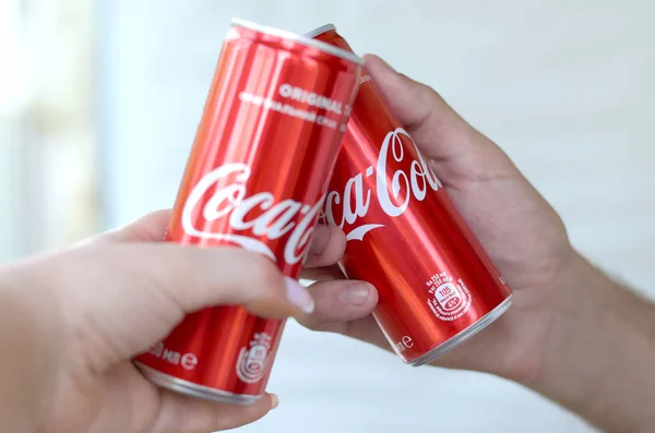 Coppia mani solleva lattine di Coca cola rossa in garage interno — Foto Stock