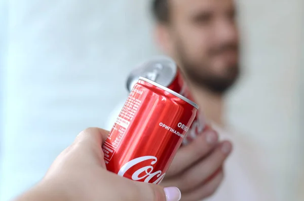 Heureux jeune homme élever Coca-Cola boîte de conserve avec un ami féminin dans l'intérieur du garage — Photo