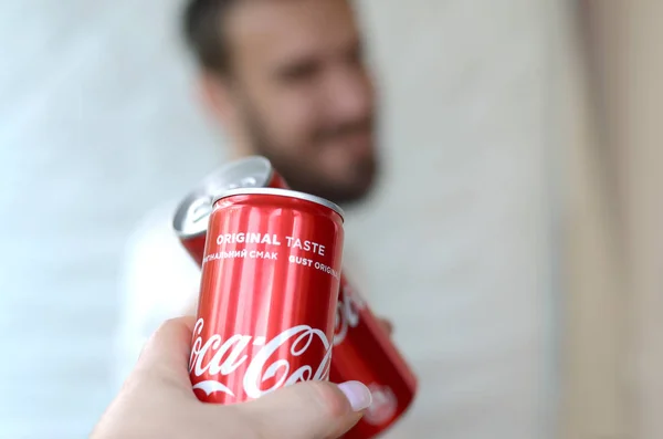 Happy young man raise Coca-Cola tin can with female friend in garage interior — Stock Photo, Image