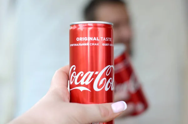 Boldog fiatalember emelje Coca-Cola ón is a női barát garázs belső — Stock Fotó