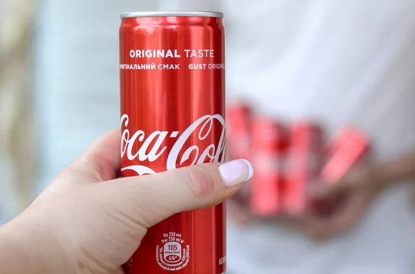 Mannlige hender holder få Coca-Cola blikkbokser i garasjens indre og kvinnelig hånd med en boks i forgrunnen – stockfoto