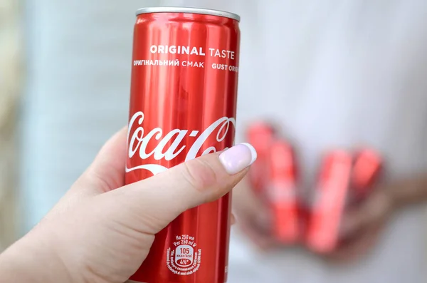 Mannlige hender holder få Coca-Cola blikkbokser i garasjens indre og kvinnelig hånd med en boks i forgrunnen – stockfoto