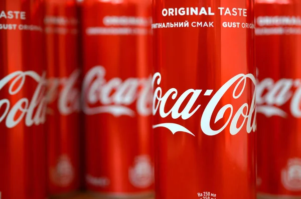 Логотип Coca-Cola напечатан на алюминиевых банках и размещен на столе торгового центра — стоковое фото