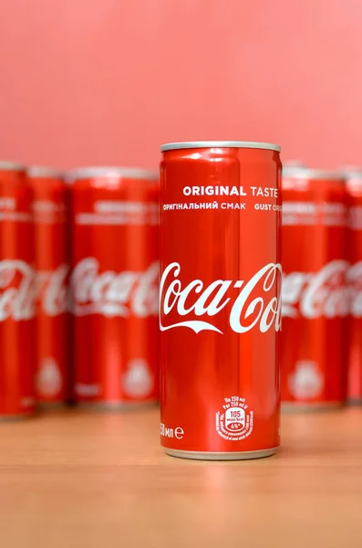 Логотип Coca-Cola напечатан на алюминиевых банках и размещен на столе торгового центра — стоковое фото