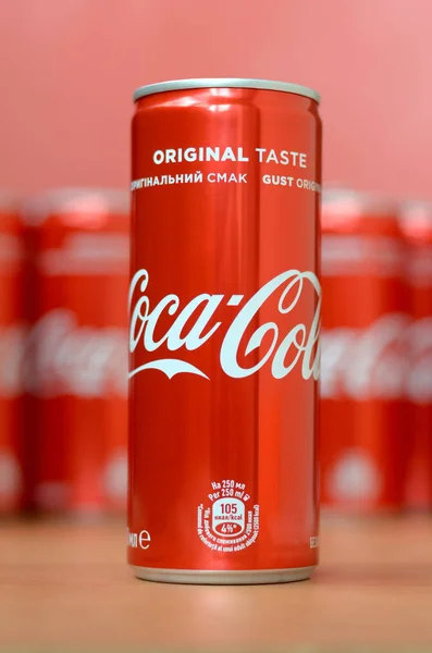 Логотип Coca-Cola напечатан на алюминиевых банках и размещен на столе торгового центра — стоковое фото