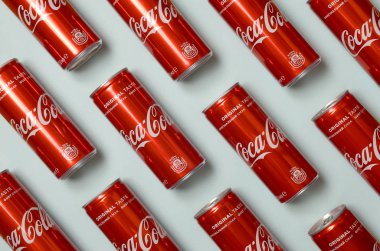 Düz yatıyordu atış karbonlu kırmızı içecek teneke kutular Coca Cola pastel mavi arka planda döşeme