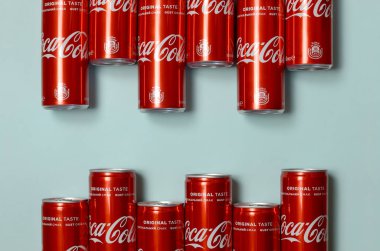 Düz yatıyordu atış karbonlu kırmızı içecek teneke kutular Coca Cola pastel mavi arka planda döşeme