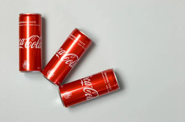 Flat lay tiro carbonatado refrigerante latas de lata Coca-Cola deitado no fundo azul — Fotografia de Stock