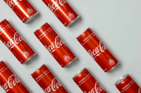 Rata ditembak berkarbonasi minuman merah kaleng kaleng Coca Cola berbaring di atas pastel biru latar belakang — Stok Foto