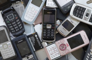 Eski kullanılan modası geçmiş cep telefonları ve piller demet. Geri dönüşüm elektroniği