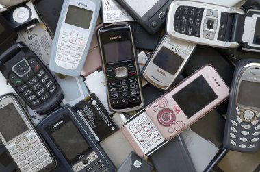 Eski kullanılan modası geçmiş cep telefonları ve piller demet. Geri dönüşüm elektroniği