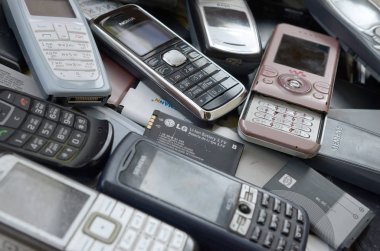 Eski kullanılan modası geçmiş cep telefonları ve piller demet. Geri dönüşüm elektroniği