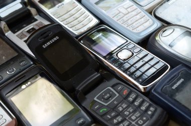 Bunch of old used outdated mobile phones. Recycling electronics in the market cheap clipart