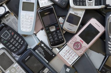 Eski kullanılan modası geçmiş cep telefonları ve piller demet. Geri dönüşüm elektroniği