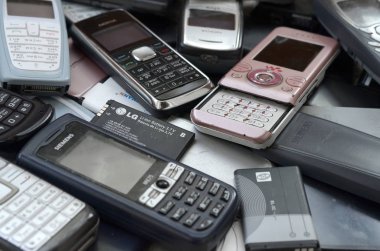 Eski kullanılan modası geçmiş cep telefonları ve piller demet. Geri dönüşüm elektroniği