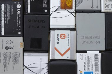 Bir sürü eski kullanılmış cep telefonu pili. Geri dönüşüm elektronik piyasada ucuz satıldı