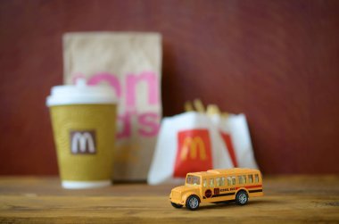 Küçük okul otobüsü ve Ahşap masa üzerinde Mcdonald's abur cubur