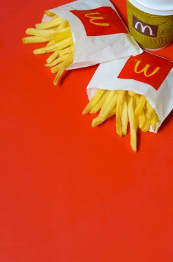 Parlak kırmızı arka plan üzerinde küçük paperbag ve kahve fincanı Mcdonald's Patates kızartması
