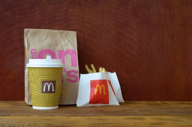 Mcdonald's ahşap masada kağıt torba ve abur cubur götürmek