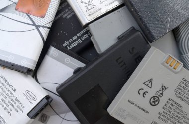 Bir sürü eski kullanılmış cep telefonu pili. Geri dönüşüm elektronik piyasada ucuz satıldı