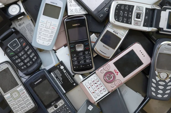 Bos van oude gebruikte verouderde mobiele telefoons en batterijen. Recycling elektronica — Stockfoto