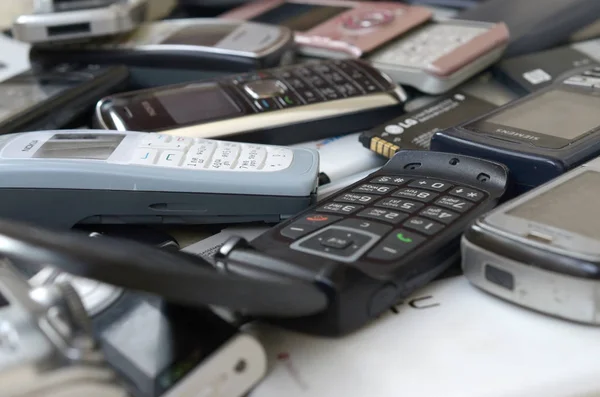 Bunch of old used outdated mobile phones and batteries. Recycling electronics — Stock Photo, Image