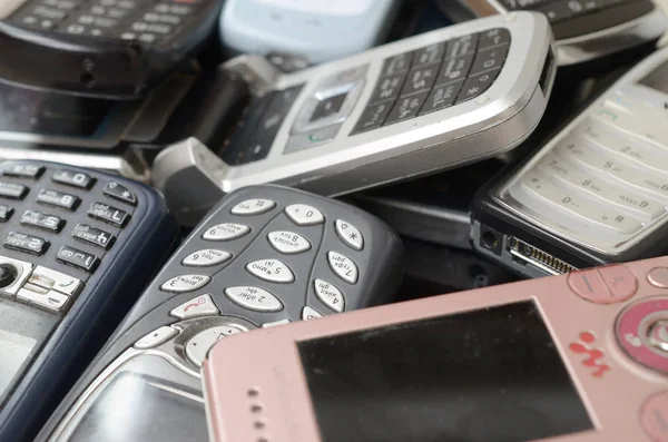 Кучка старых устаревших мобильных телефонов. Переработка электроники на рынке дешево — стоковое фото