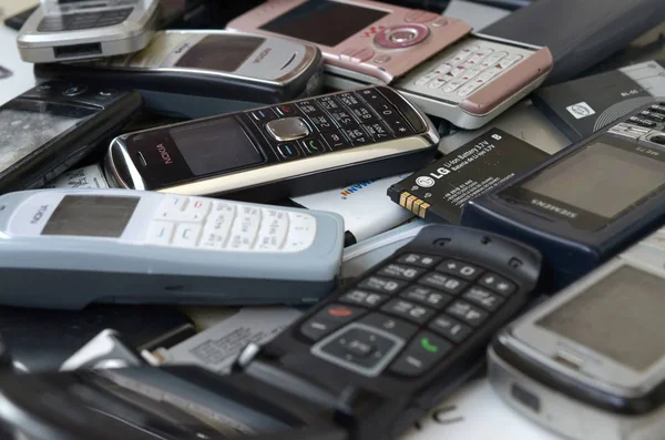 Bunch of old used outdated mobile phones and batteries. Recycling electronics — Stock Photo, Image