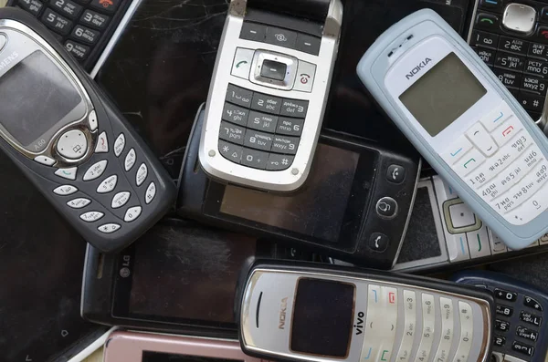 Uns telemóveis desactualizados usados. Reciclagem eletrônica no mercado barato — Fotografia de Stock