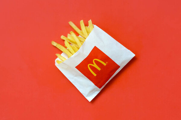 McDonald's French fries in small paperbag on bright red background