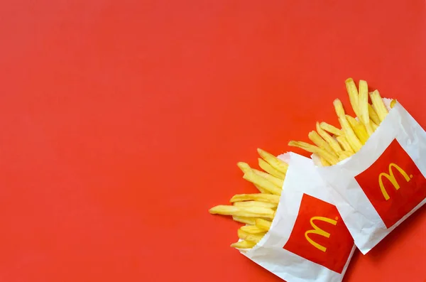 Patatas fritas McDonald 's en una pequeña bolsa de papel sobre fondo rojo brillante —  Fotos de Stock