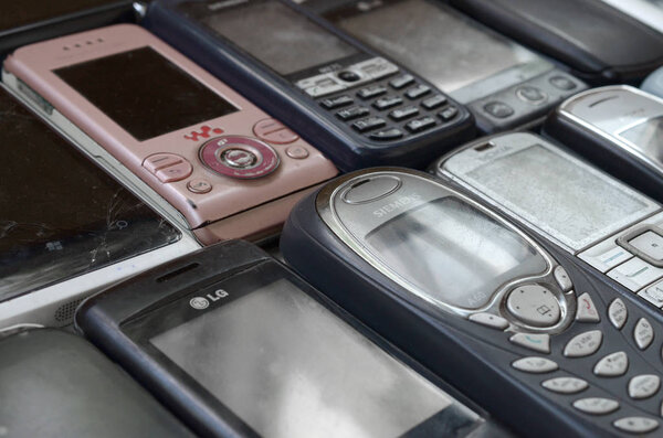 Bunch of old used outdated mobile phones. Recycling electronics in the market cheap