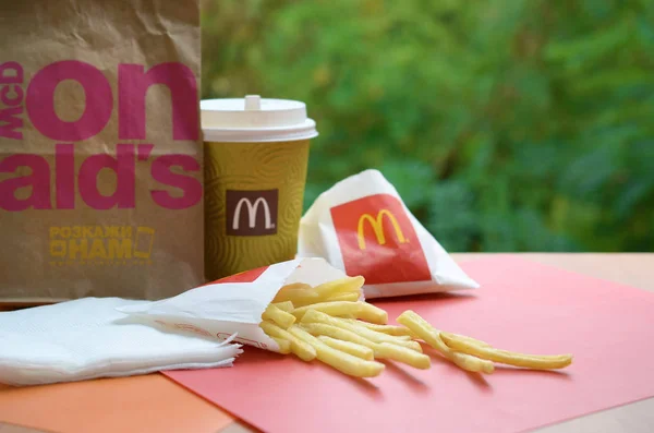 McDonald 's si vzal papírový sáček a jídlo na dřevěném stole venku — Stock fotografie