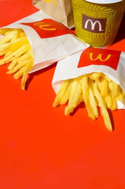 Parlak kırmızı arka plan üzerinde küçük paperbag ve kahve fincanı Mcdonald's Patates kızartması
