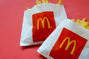 Parlak kırmızı arka plan üzerinde küçük paperbag Mcdonald's Patates kızartması