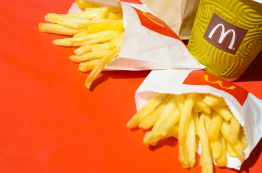 Parlak kırmızı arka plan üzerinde küçük paperbag ve kahve fincanı Mcdonald's Patates kızartması