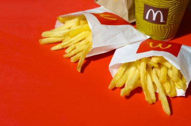 Parlak kırmızı arka plan üzerinde küçük paperbag ve kahve fincanı Mcdonald's Patates kızartması