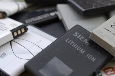 Bir sürü eski kullanılmış cep telefonu pili. Geri dönüşüm elektronik piyasada ucuz satıldı