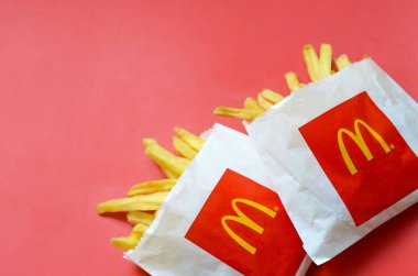 Parlak kırmızı arka plan üzerinde küçük paperbag Mcdonald's Patates kızartması