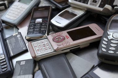 Eski kullanılan modası geçmiş cep telefonları ve piller demet. Geri dönüşüm elektroniği