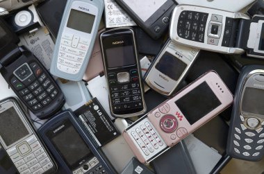 Eski kullanılan modası geçmiş cep telefonları ve piller demet. Geri dönüşüm elektroniği