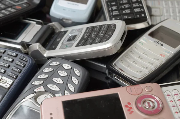 Kilka starych używanych przestarzałych telefonów komórkowych. Recykling elektroniki na rynku Tanie — Zdjęcie stockowe