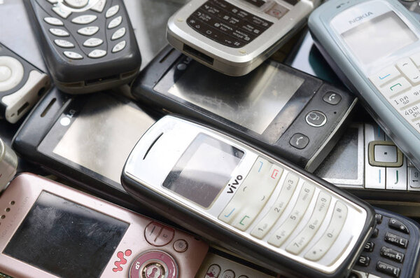 Bunch of old used outdated mobile phones. Recycling electronics in the market cheap