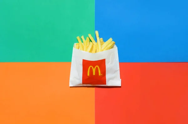 McDonald 's French goreng dalam kantong kertas kecil dengan latar belakang berwarna cerah — Stok Foto