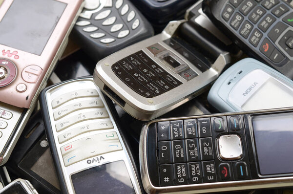 Bunch of old used outdated mobile phones. Recycling electronics in the market cheap