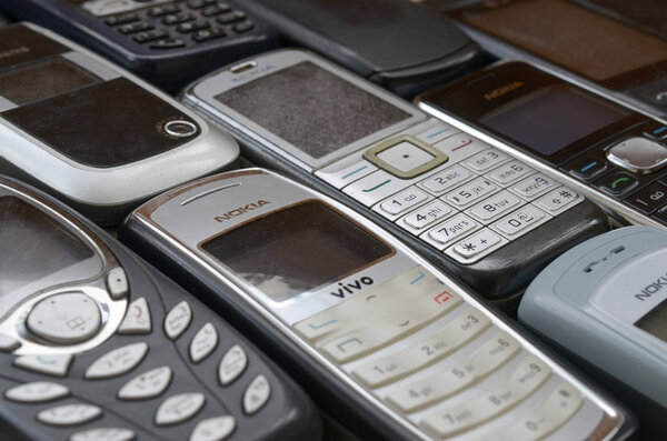Bunch of old used outdated mobile phones. Recycling electronics in the market cheap