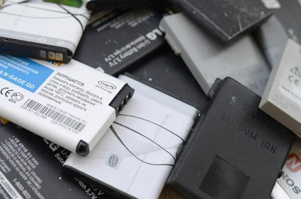 Um bando de antigas baterias de telemóveis usadas. Reciclagem eletrônica foi vendida no mercado barato — Fotografia de Stock