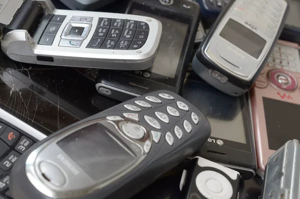 Kilka starych używanych przestarzałych telefonów komórkowych. Recykling elektroniki na rynku Tanie — Zdjęcie stockowe